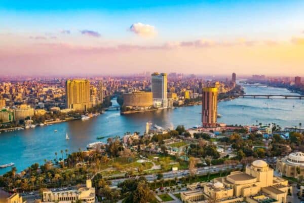 Vista da cidade do Cairo, no Egito. Vemos prédios, vegetação e o Rio Nilo atravessando a cidade.