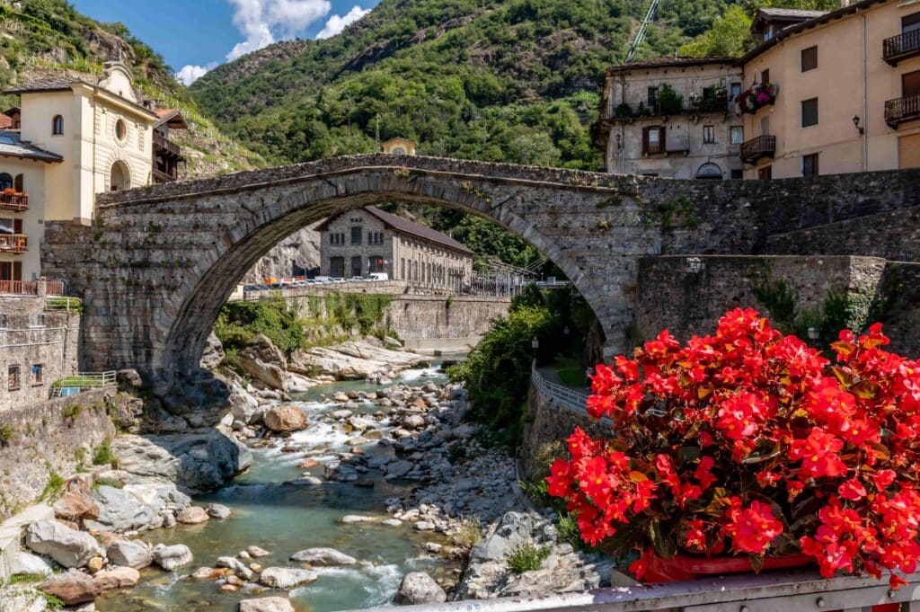 Lindas flores vermelhas decoram o centro histórico de Pont Saint Martin, Valle d'Aosta, Itália, perto da antiga ponte romana.