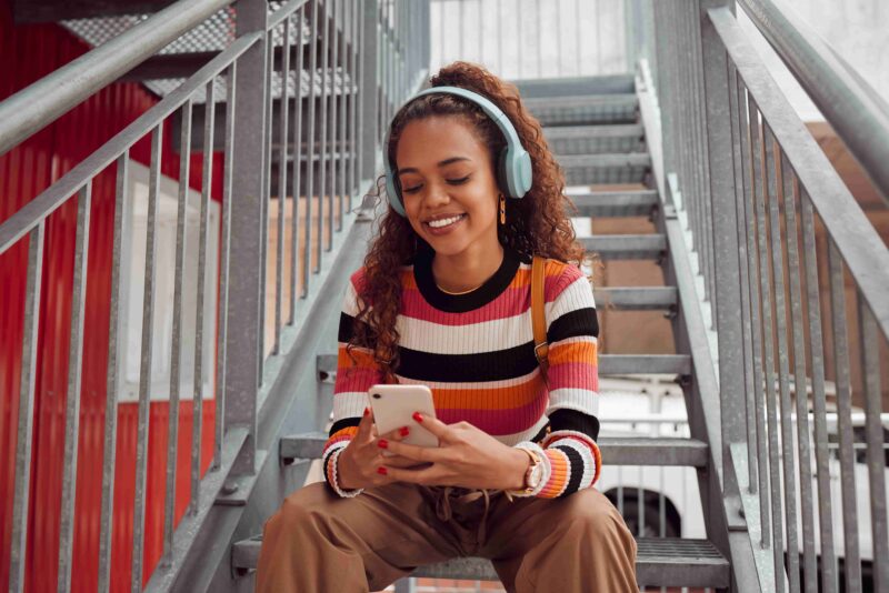 Estudante escuta música brasileira em versão espanhola nos seus headphones. 