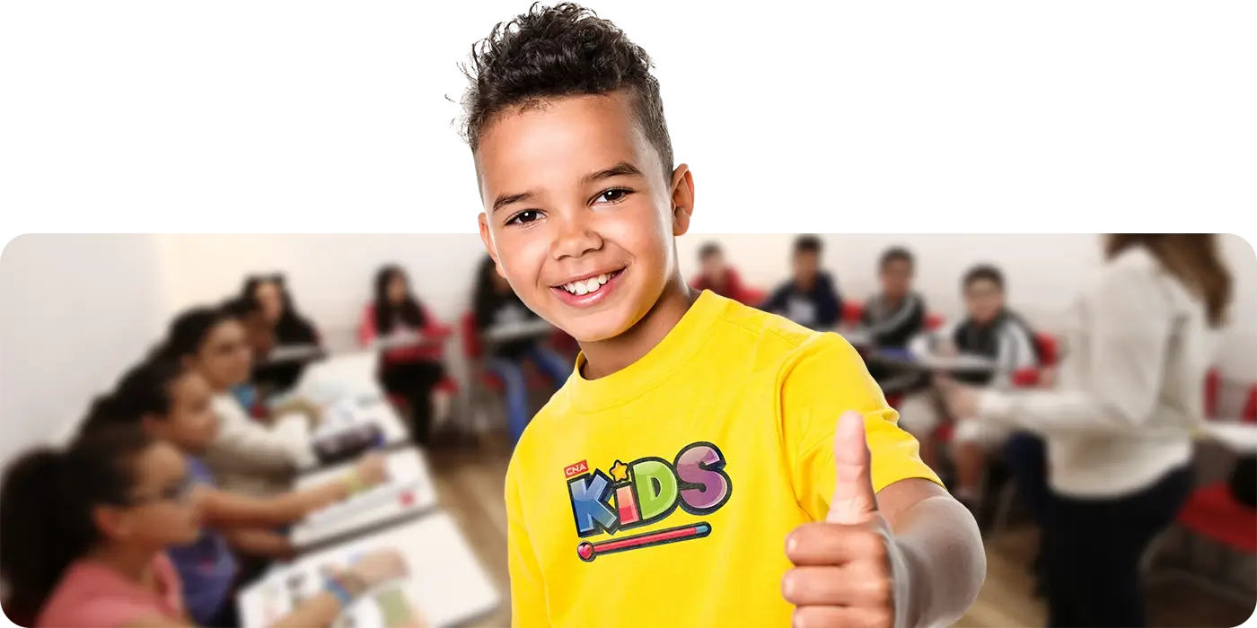 Criança entre 3 a 4 anos de idade sorrindo dentro de uma sala de aula CNA com temática Disney