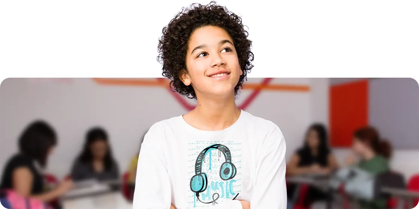 Criança entre 3 a 4 anos de idade sorrindo dentro de uma sala de aula CNA com temática Disney