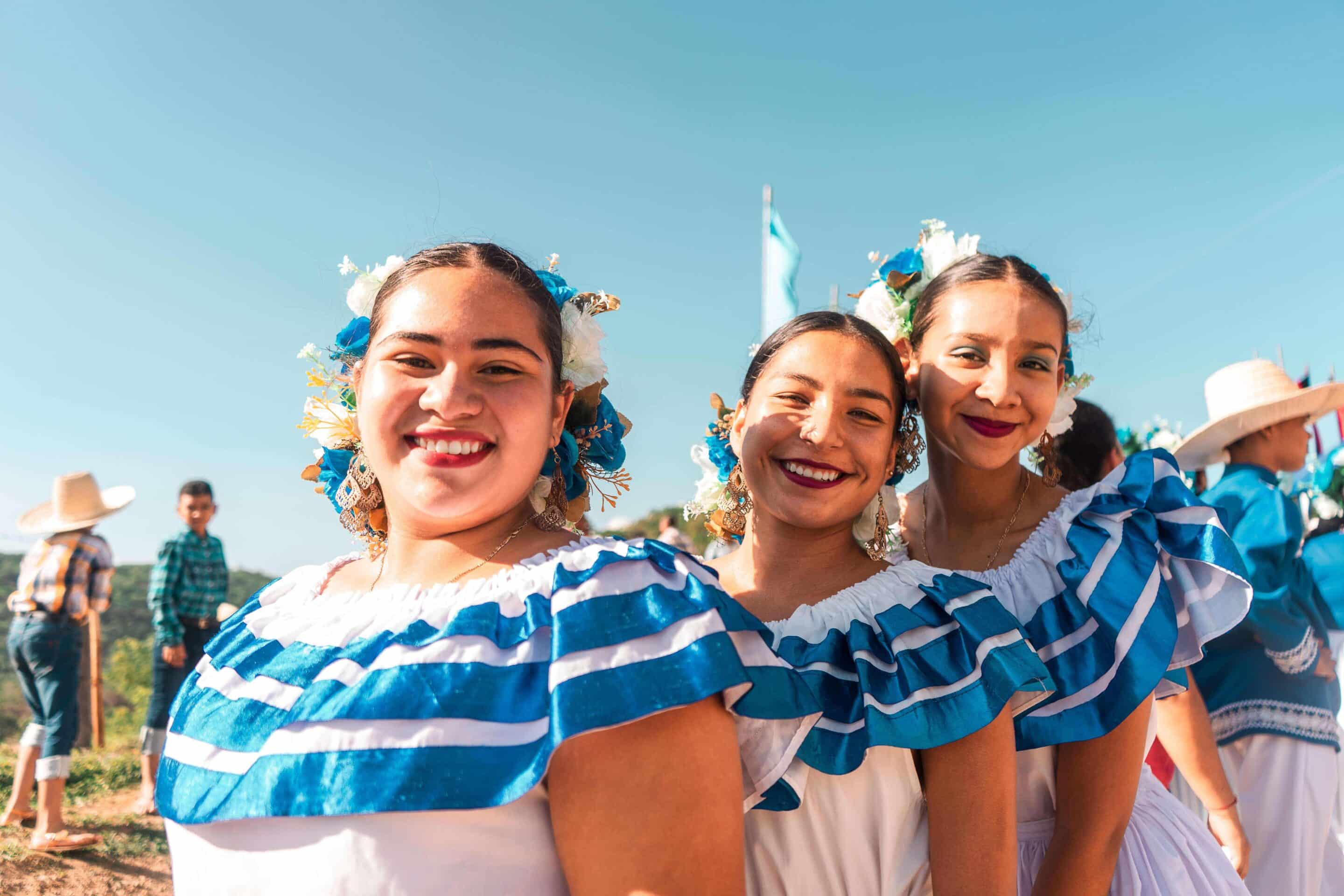 Meninas usando trajes tradicionais nicaraguenses em uma paisagem montanhosa de Rivas, representando a cultura viva e autêntica da Nicarágua.